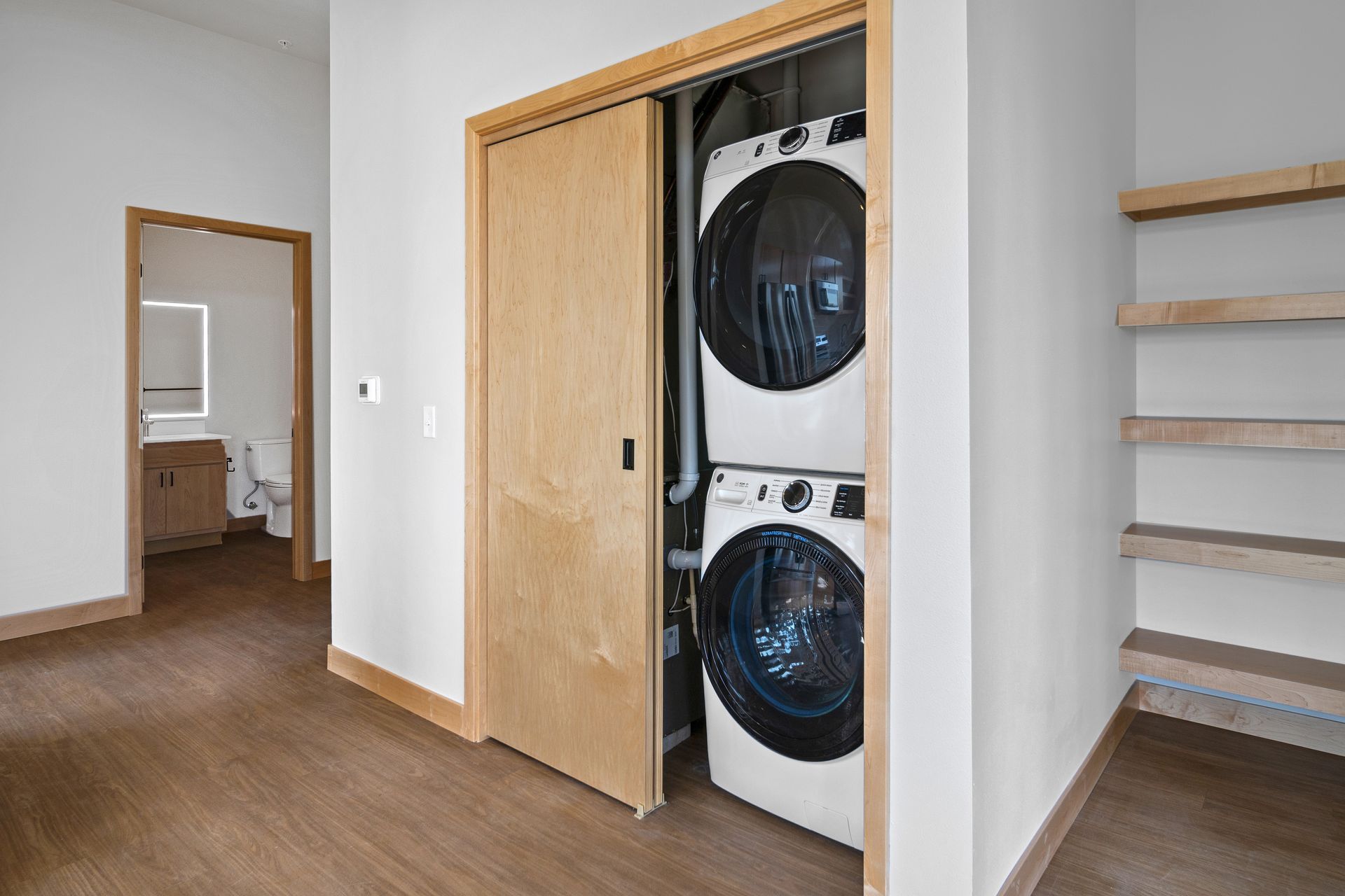 A washer and dryer are stacked on top of each other in a closet.