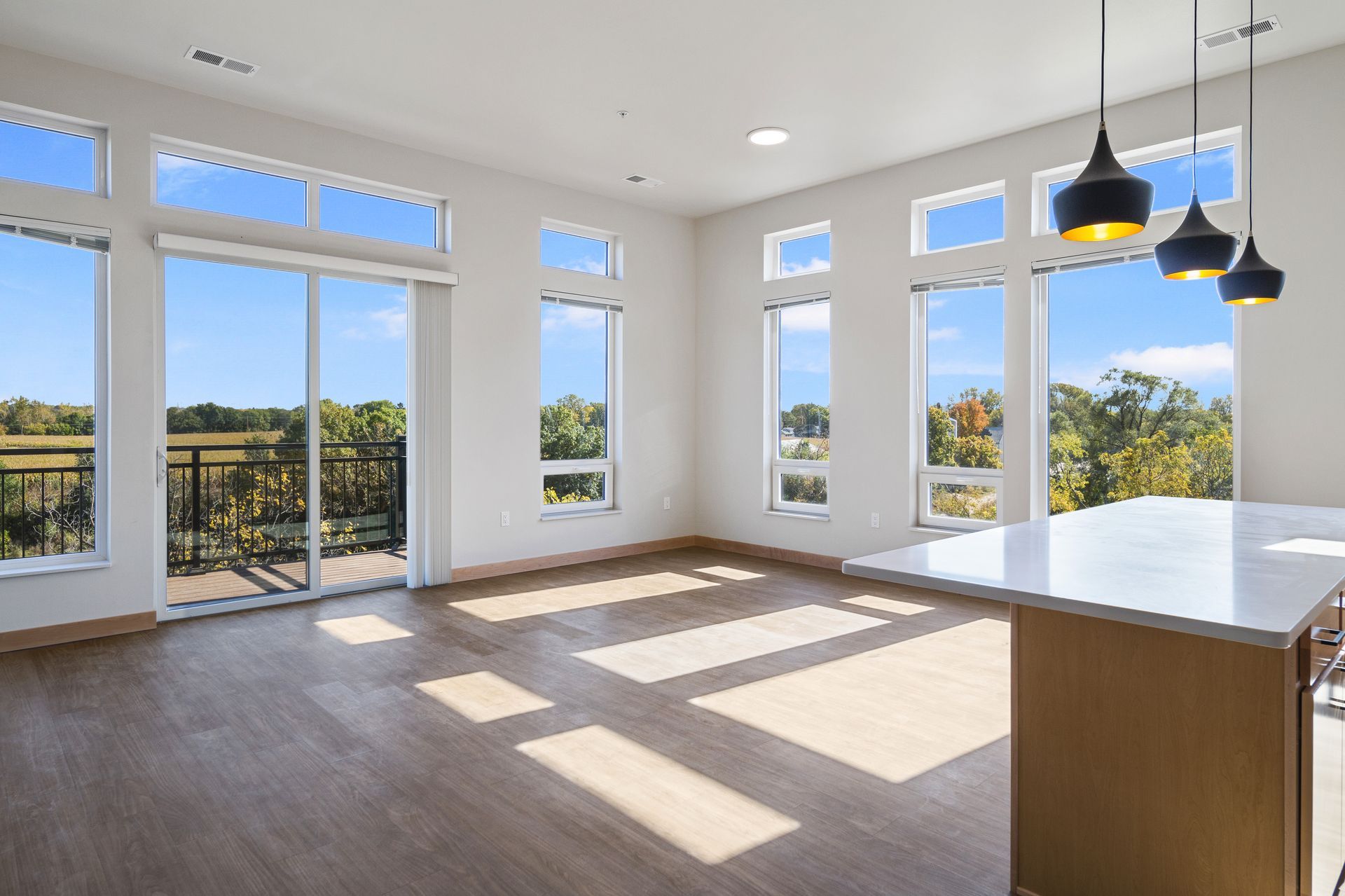 A large open livingroom with lots of windows and a balcony.