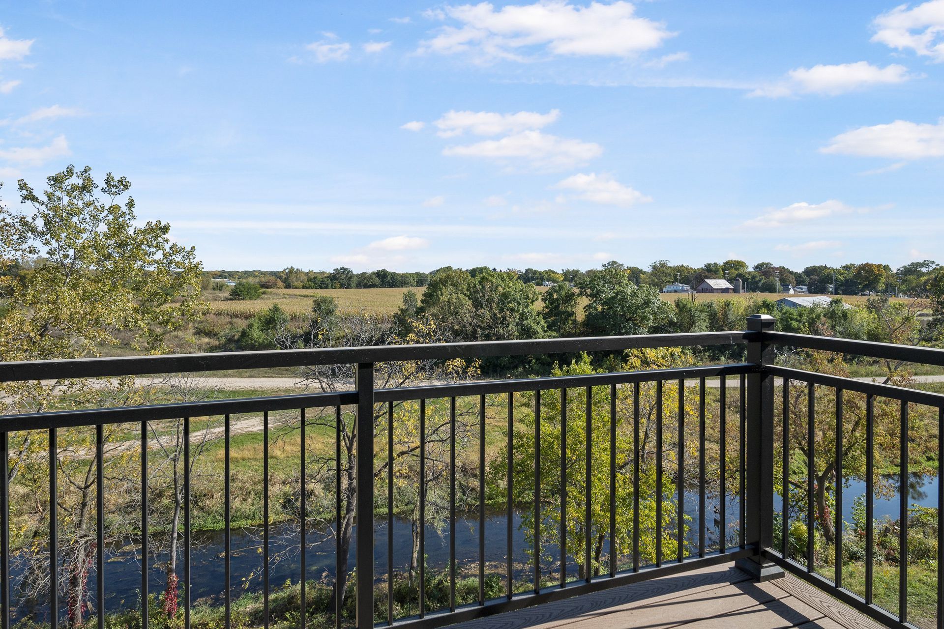 A balcony with a view of a river and trees.