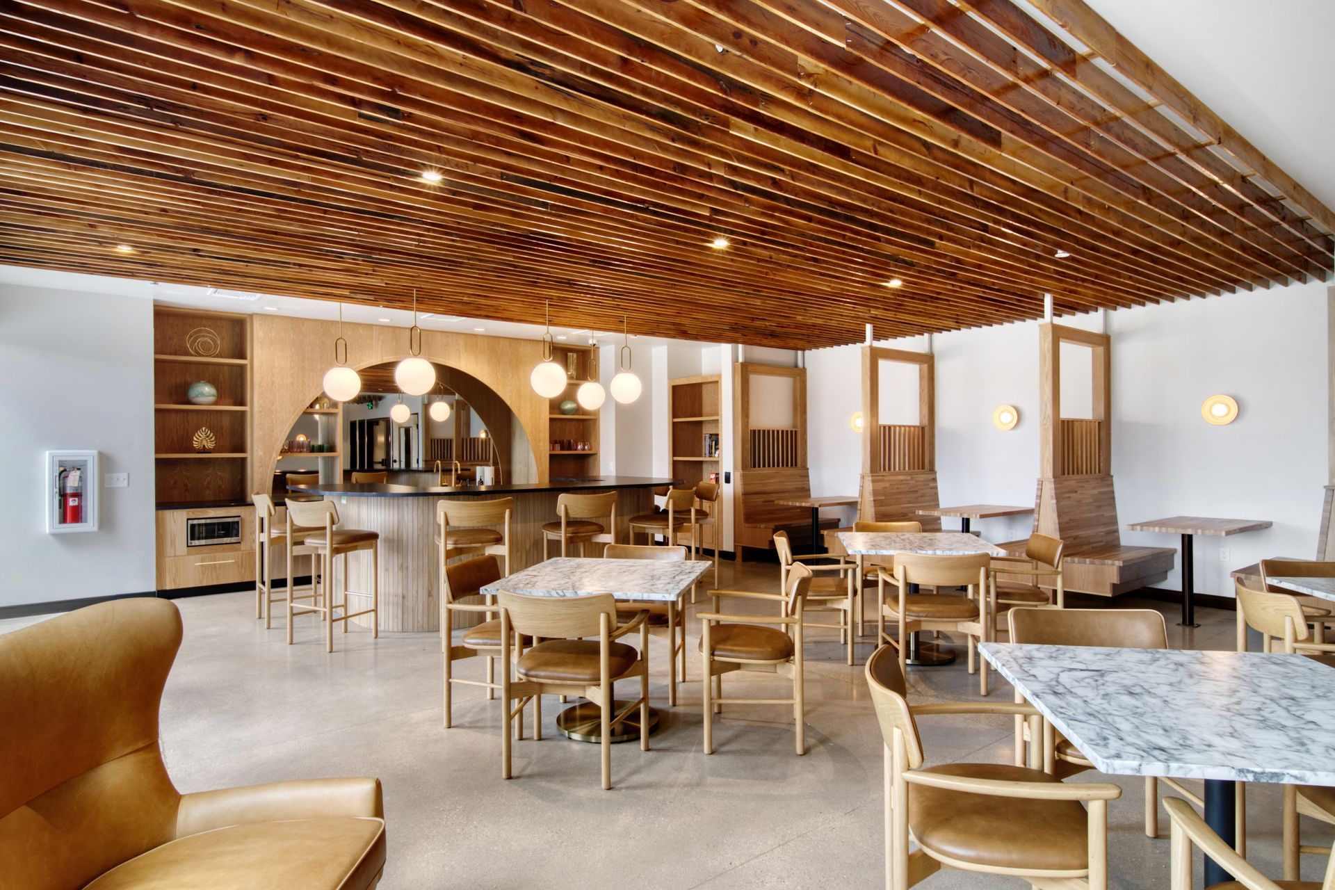 A large room with tables and chairs and a wooden ceiling.