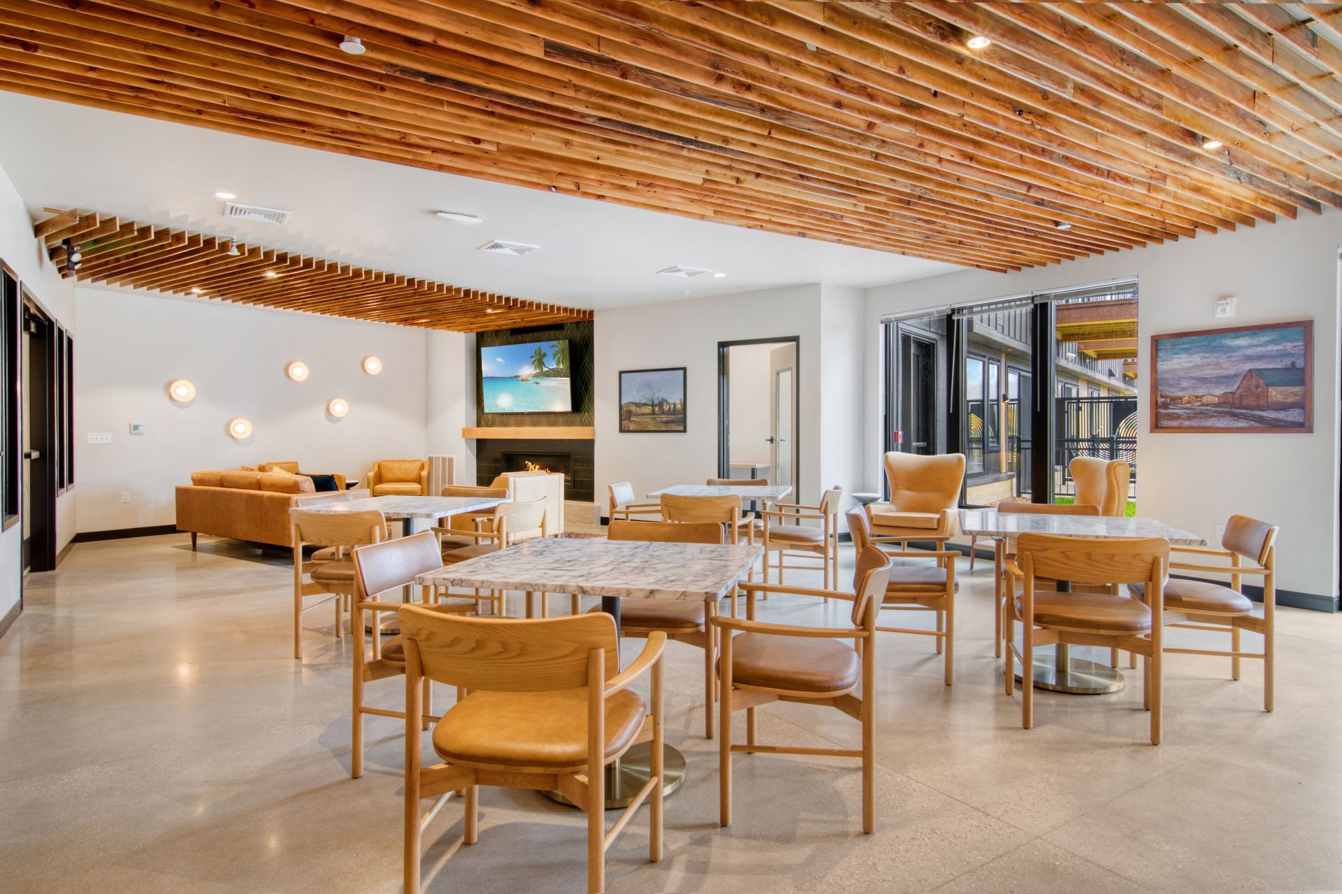 A large room with tables and chairs and a wooden ceiling.