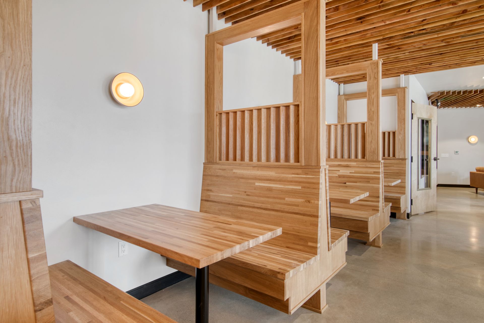 A row of wooden tables and benches in a restaurant.