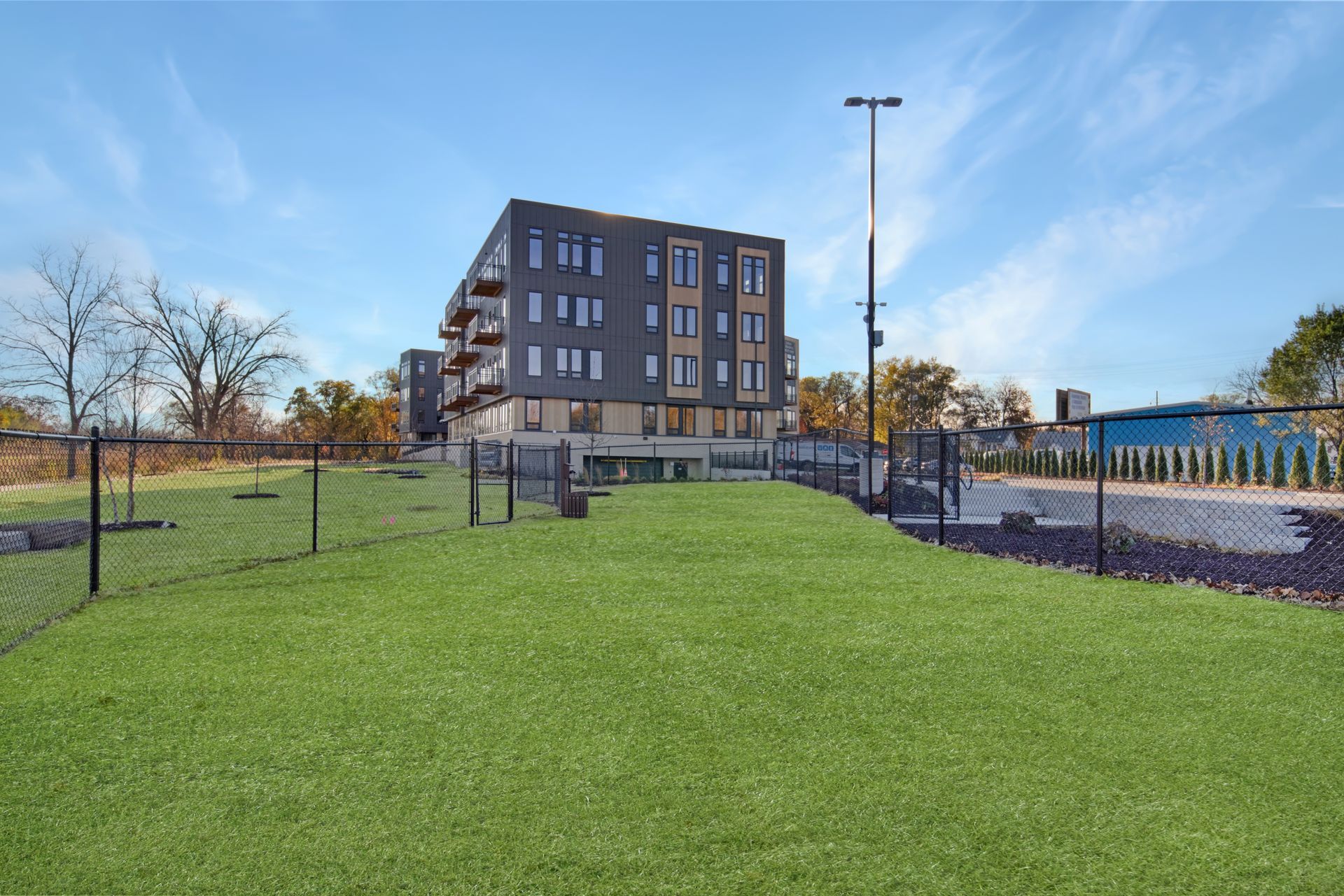 An artist 's impression of a dog park with a building in the background.