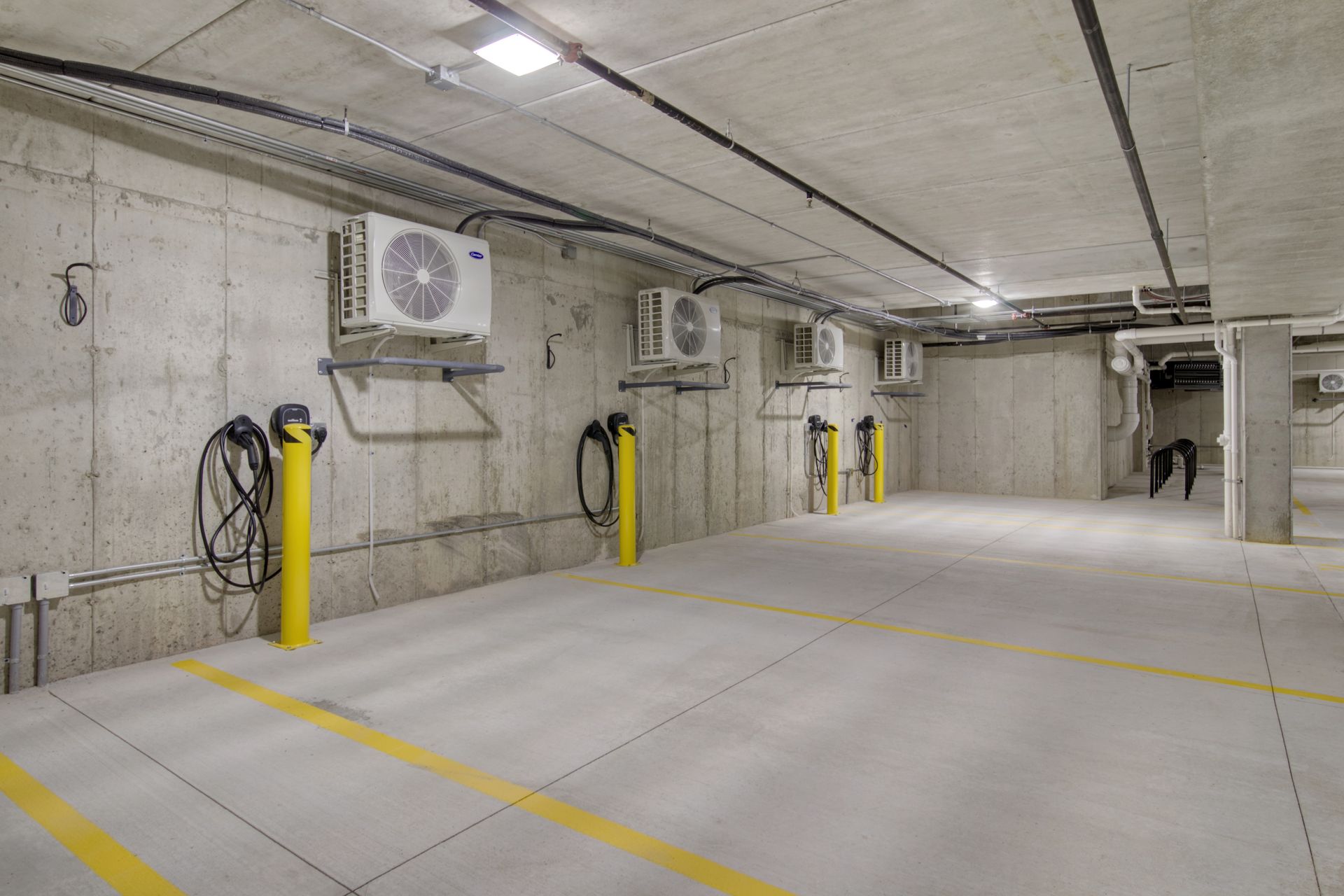 A parking garage with a lot of air conditioners on the wall.