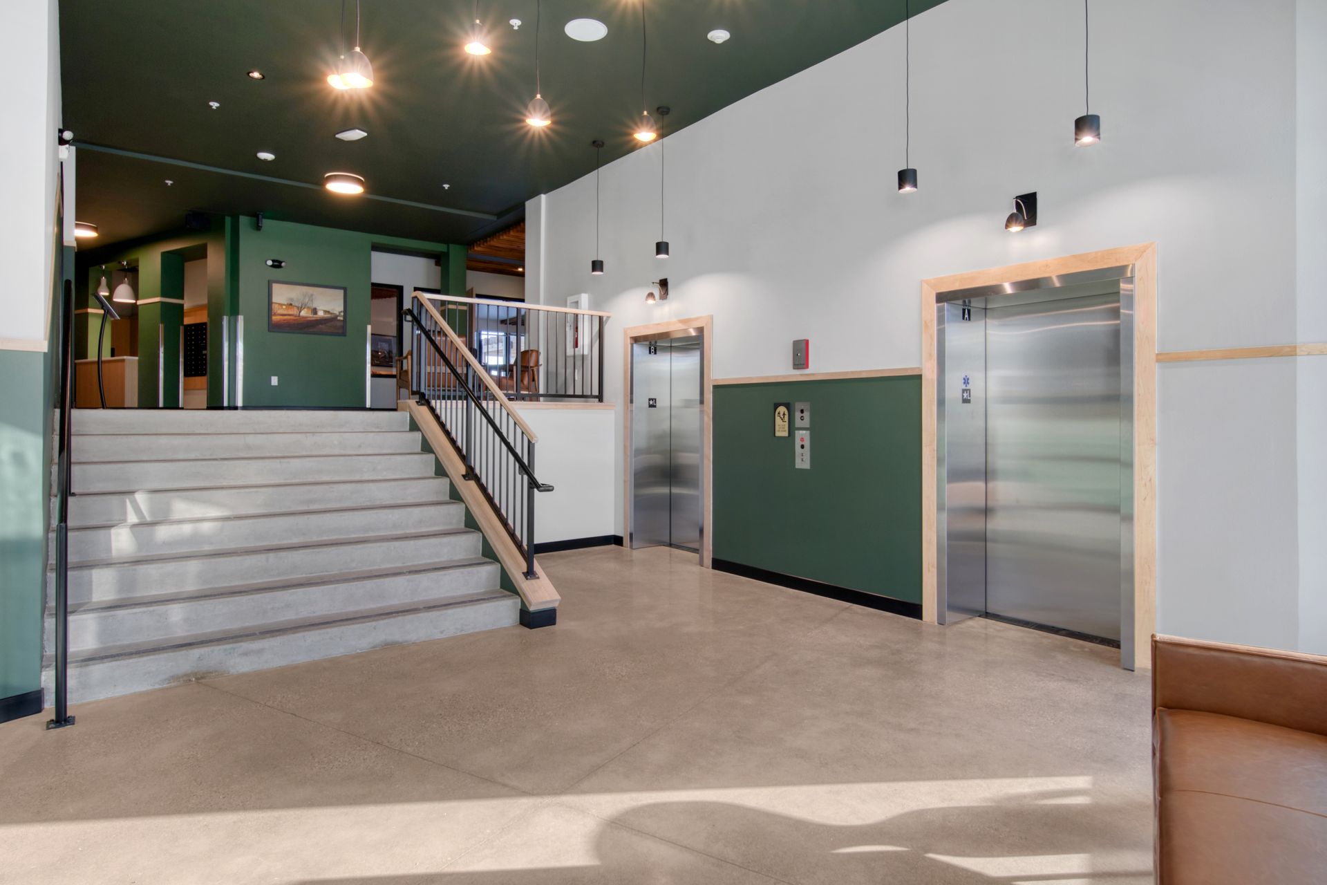 A lobby with stairs and elevators in a building.