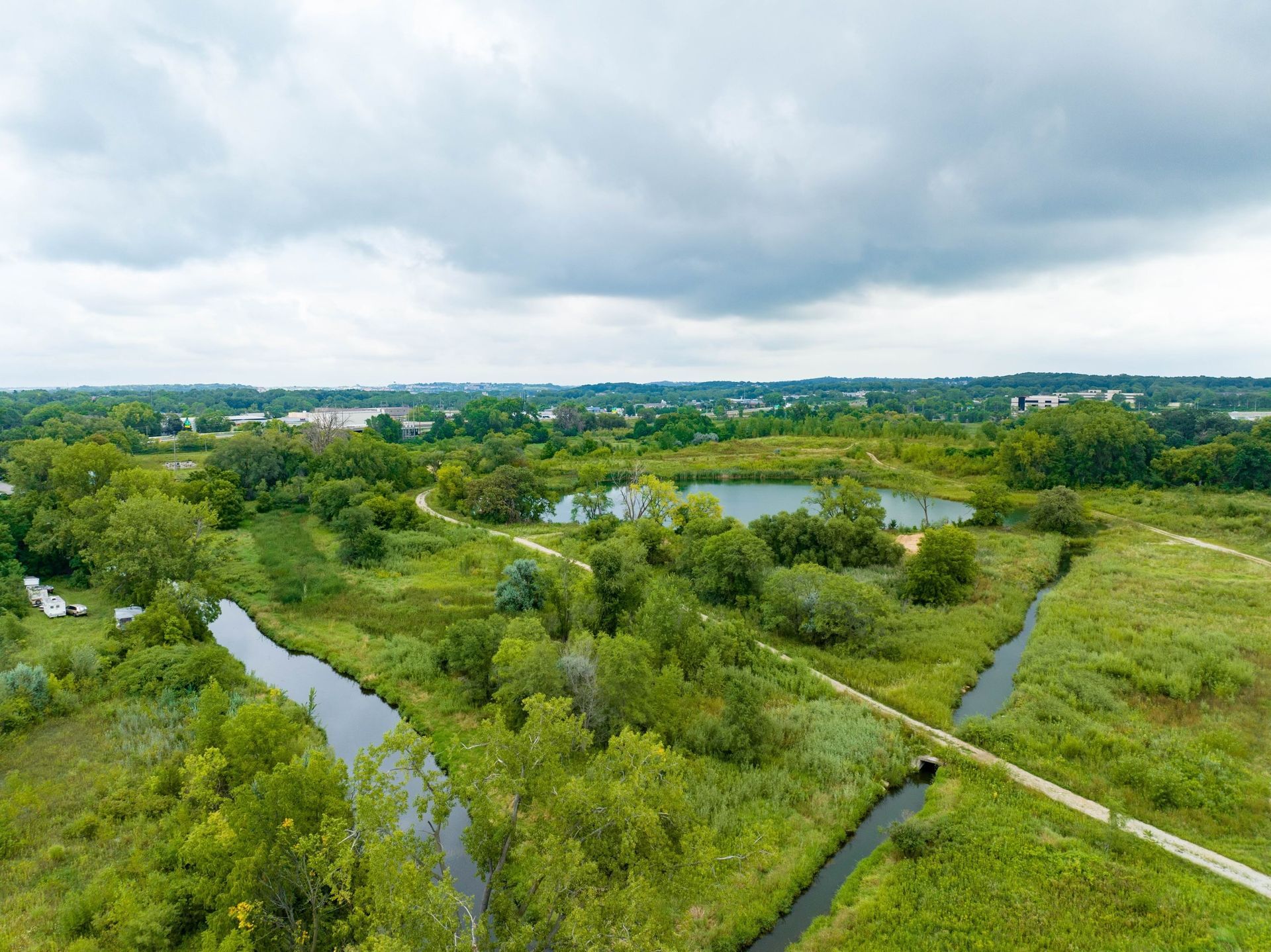 An aerial view of a river running through a lush green field.