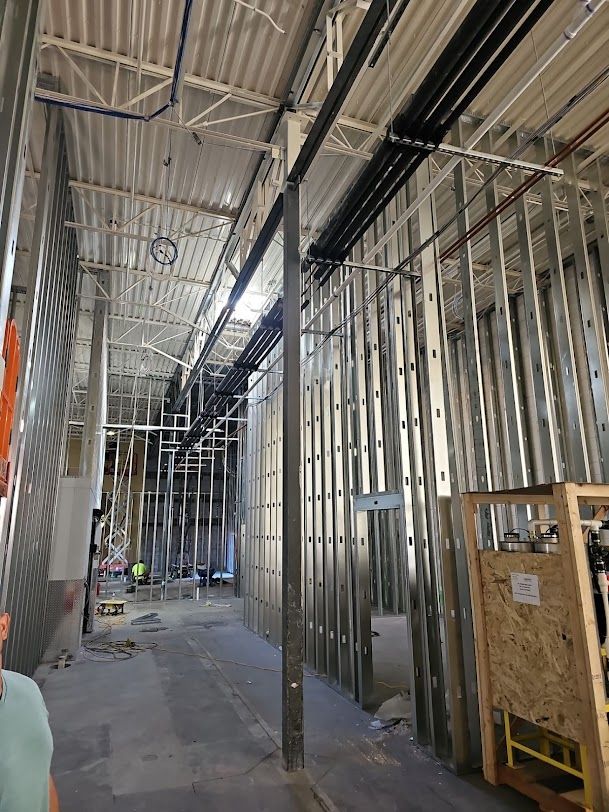 A large building under construction with a lot of pipes hanging from the ceiling.