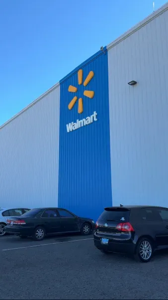 A walmart store with cars parked in front of it