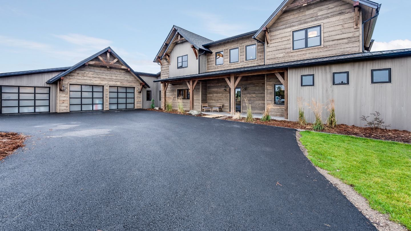 Sunroom with wooden frame, glass windows, plants, table, chairs, and white armchairs.