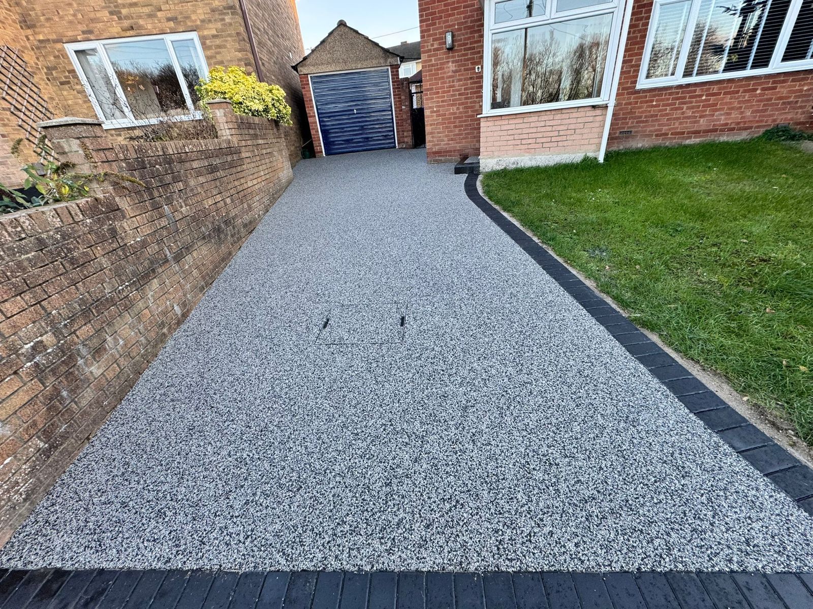Sunroom with white frame and ceiling, beige couches, orange pillows, and view of greenery.