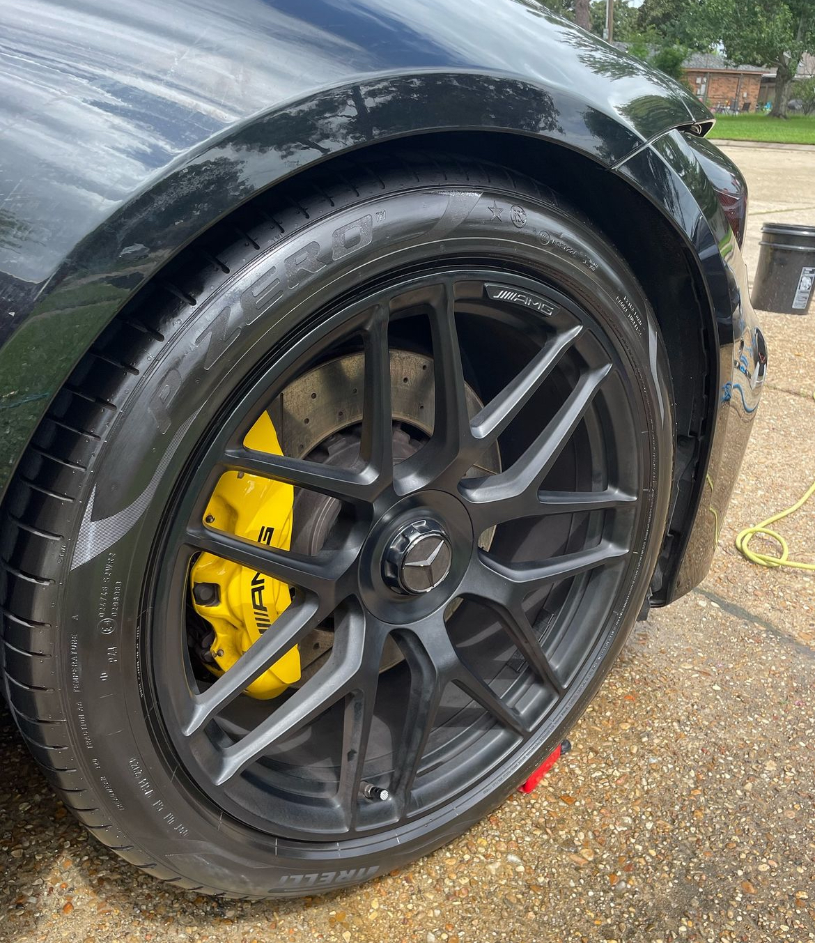 A close up of a car wheel with a yellow brake caliper.