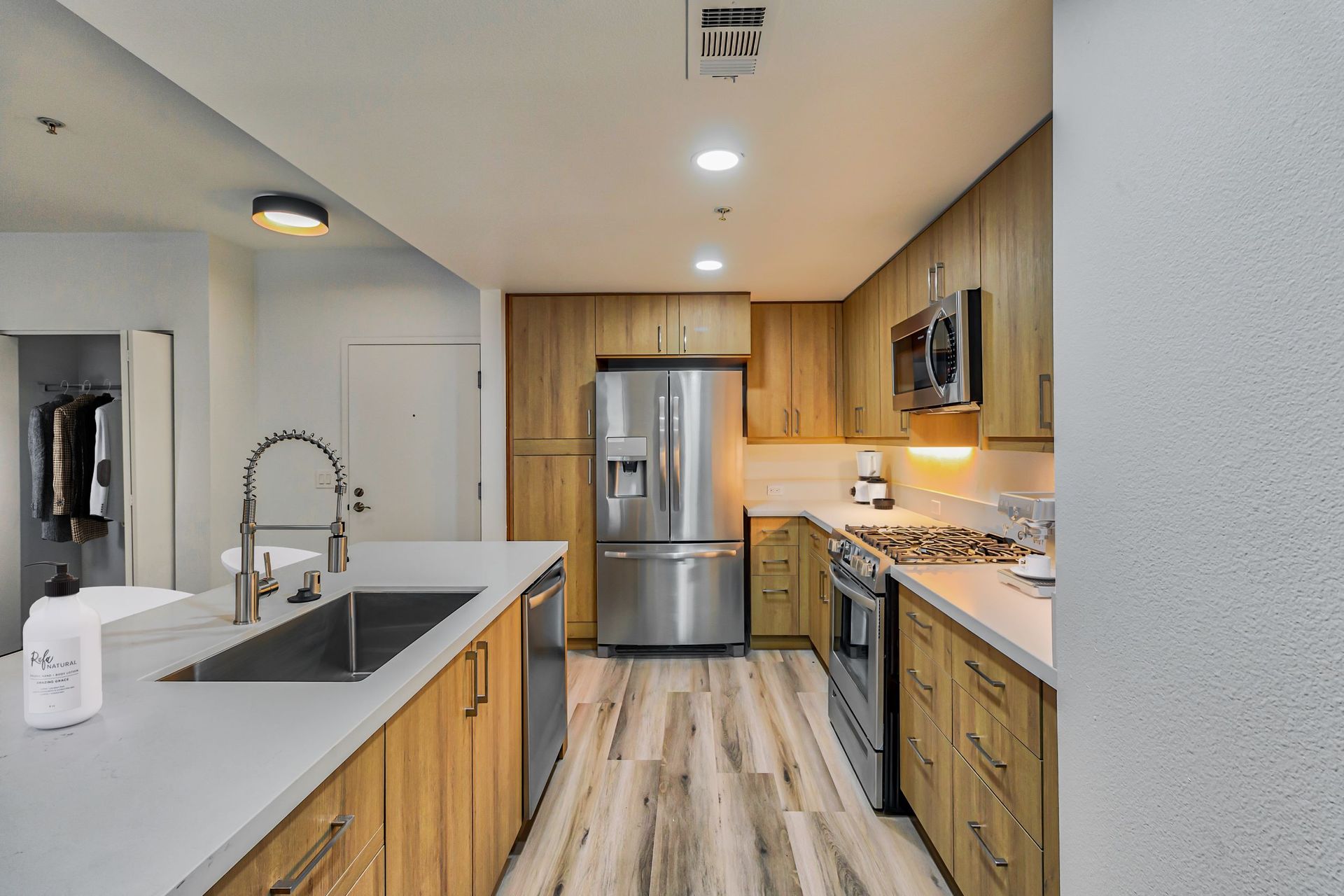 A kitchen with stainless steel appliances and wooden cabinets.