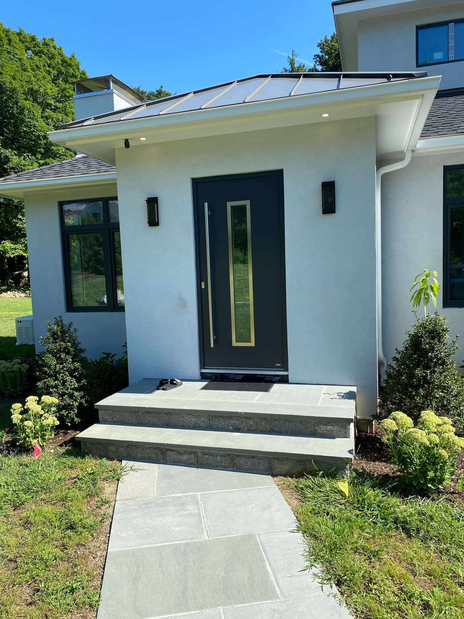 A white house with a black door and steps