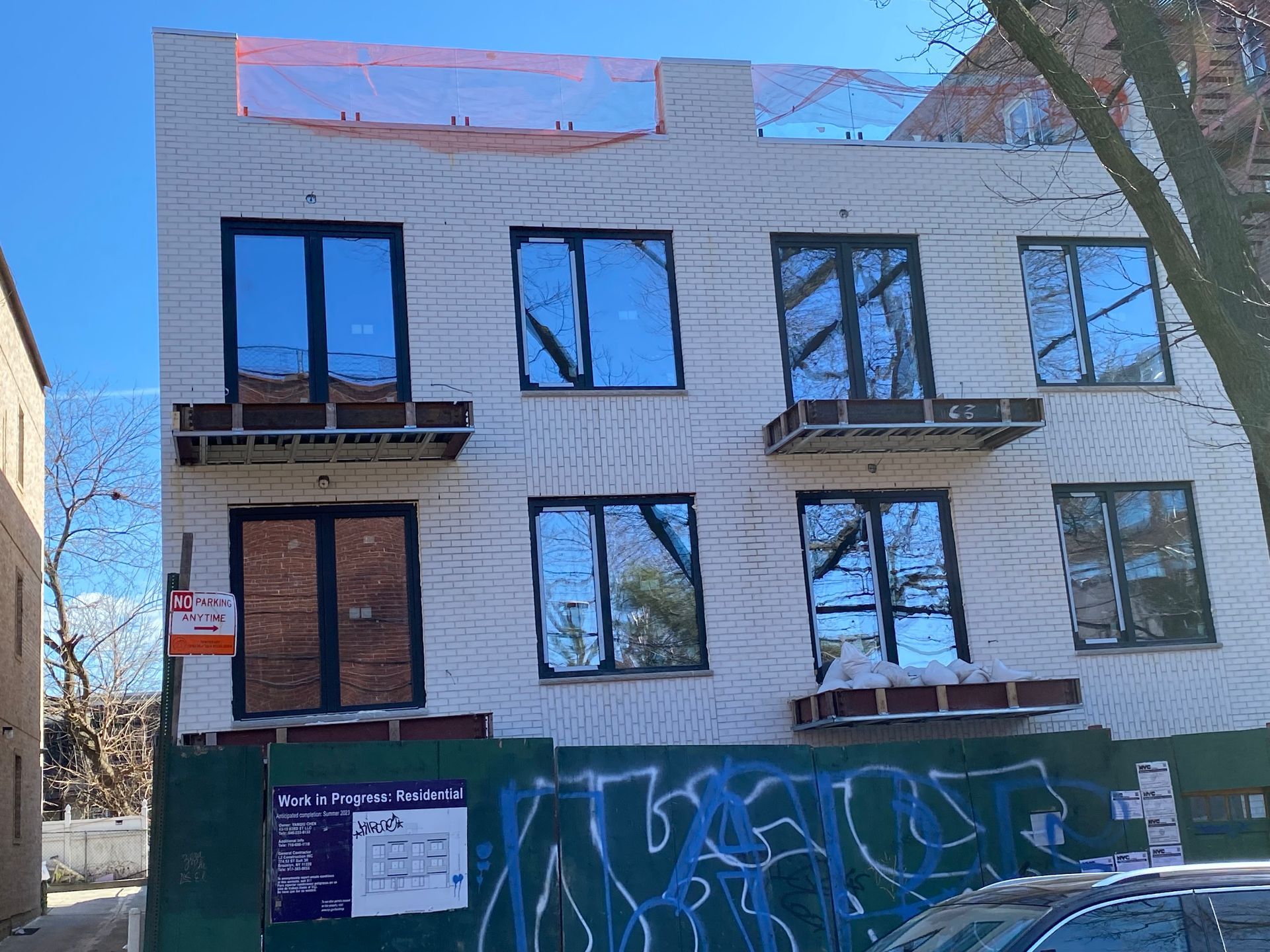 A building under construction with graffiti on the side of it.