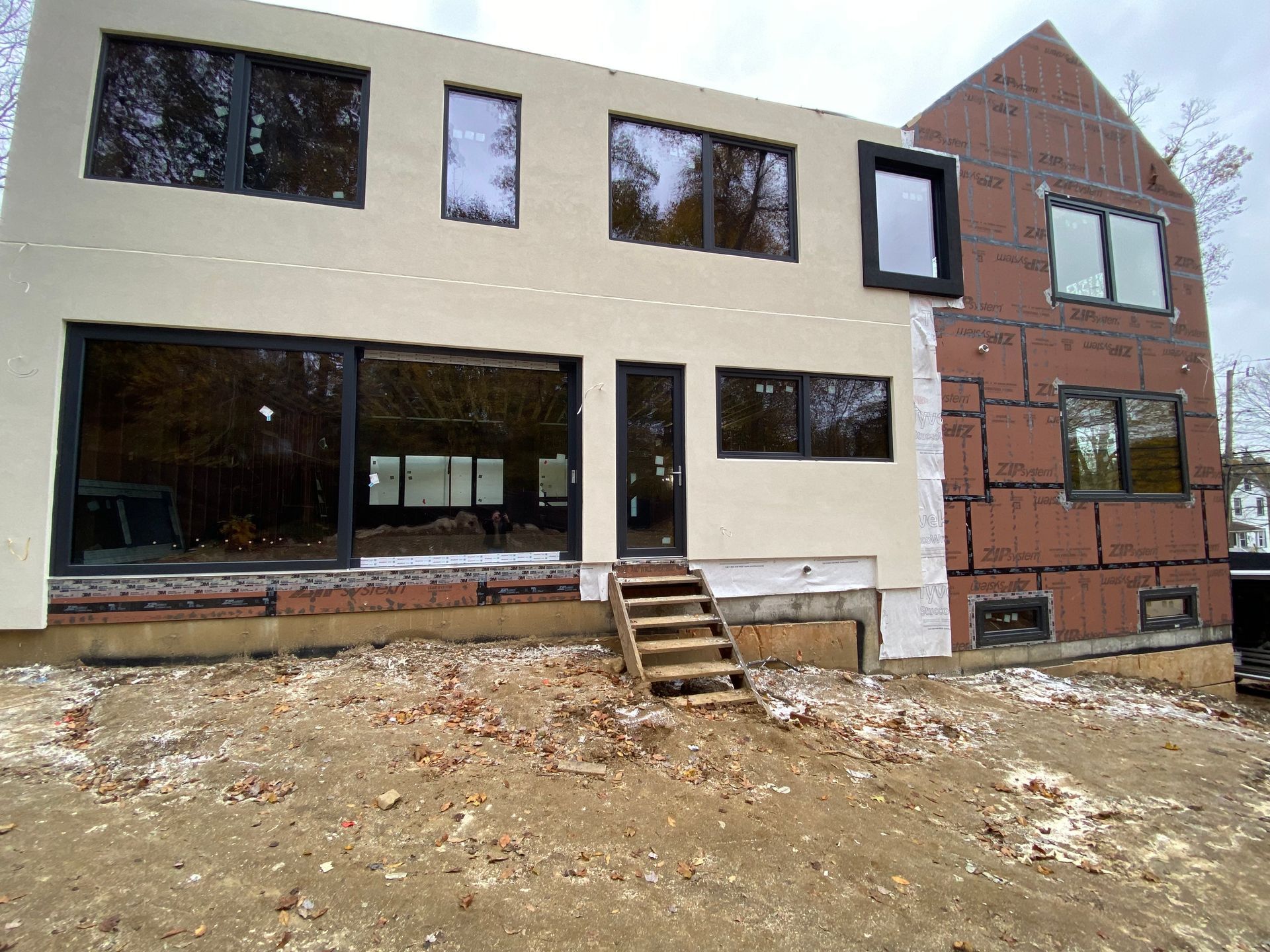 A large house with a lot of windows is being built.