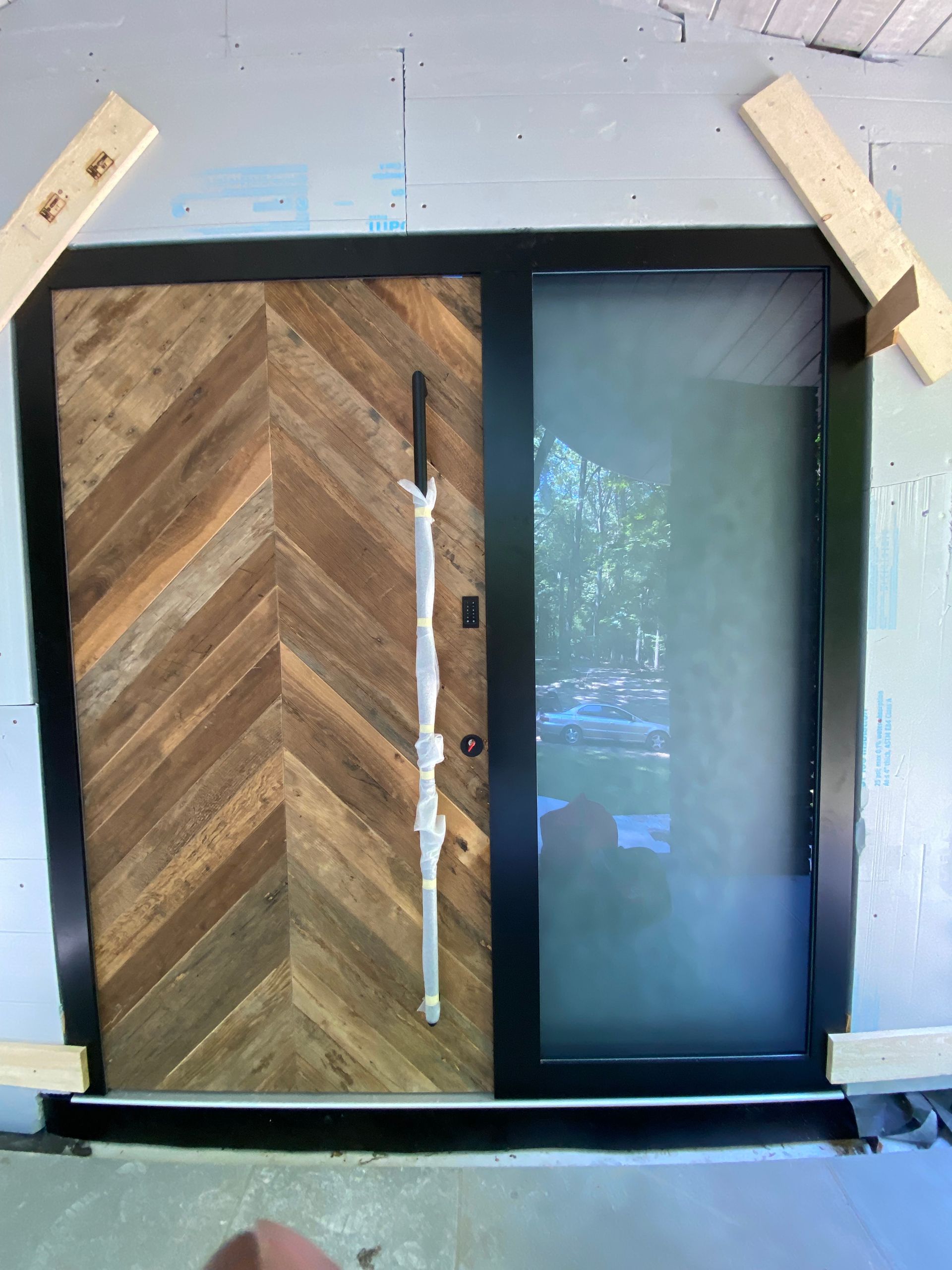 A wooden door with a chevron pattern and a glass door