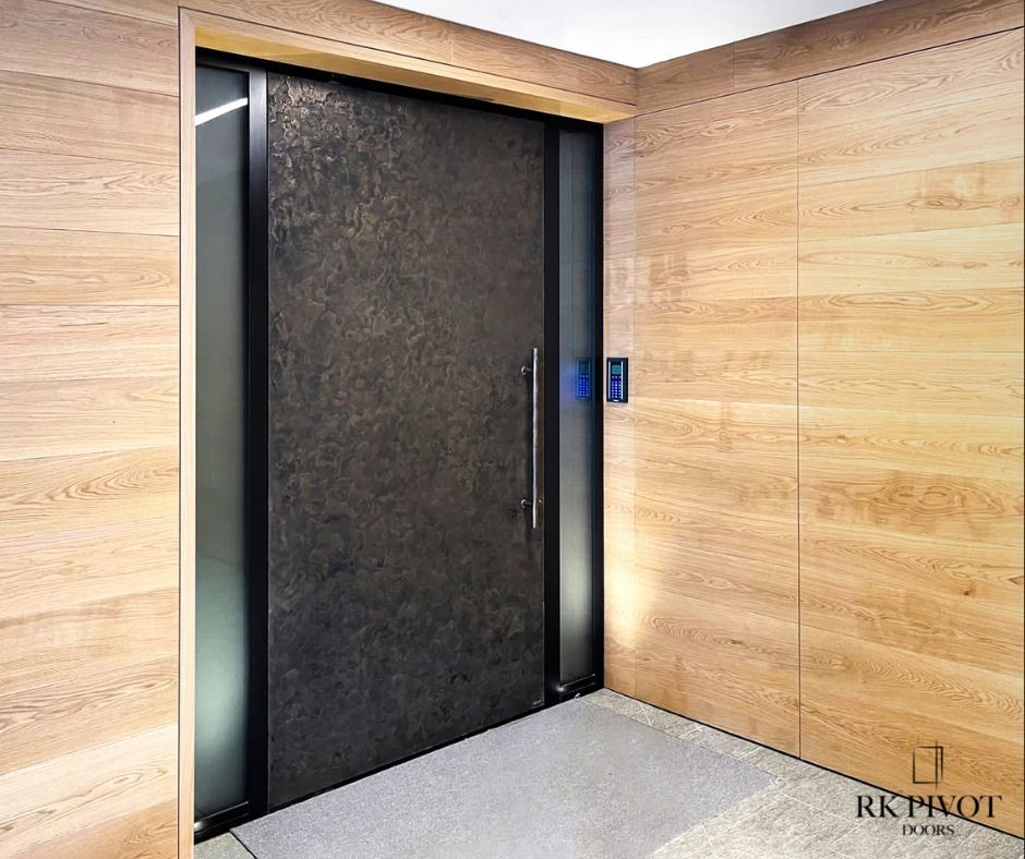 A large black door is in a room with wooden walls.