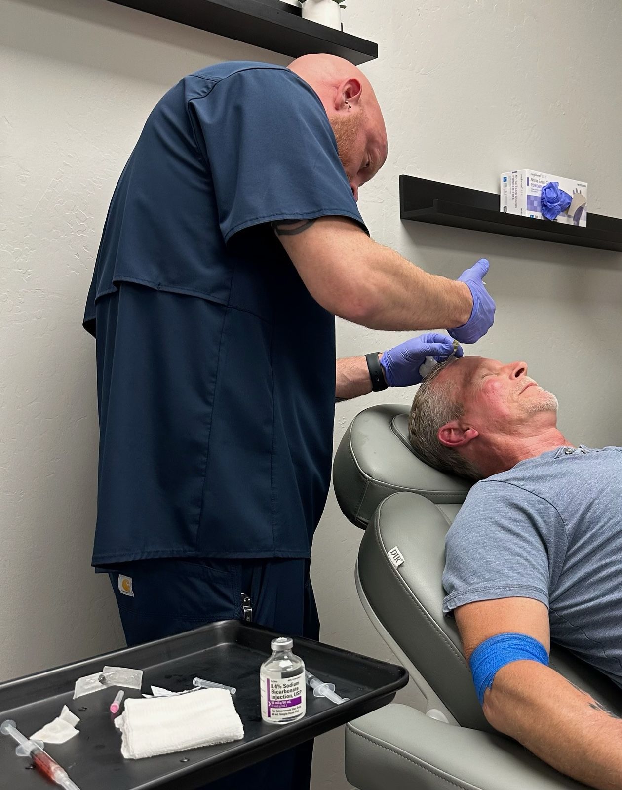 A man during vampire hair restoration procedure while laying in a chair.