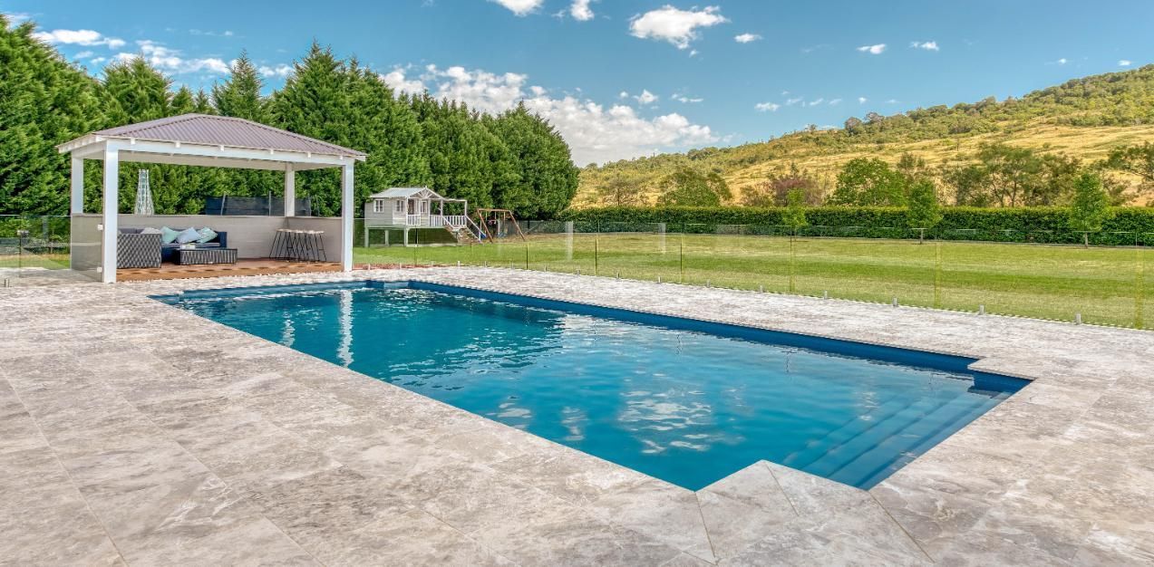 A large swimming pool with a gazebo in the background.