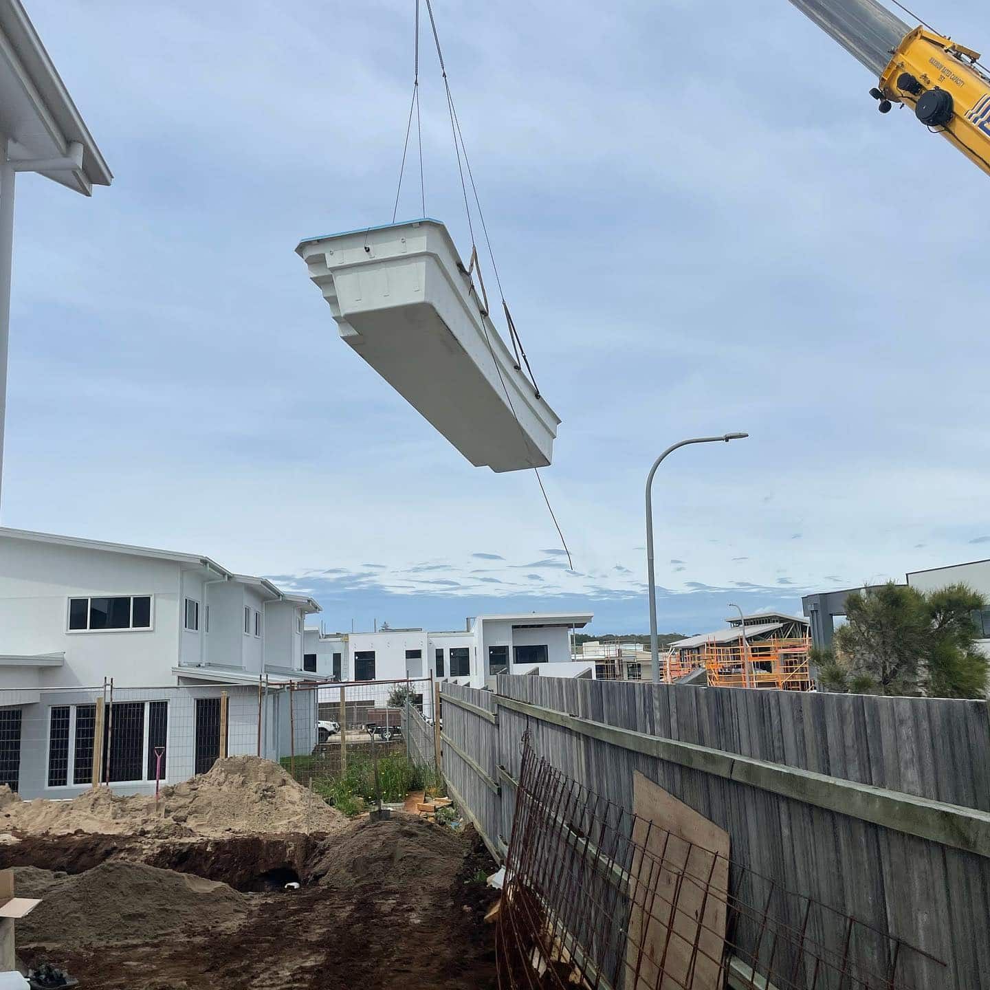 A crane is lifting a swimming pool into the air