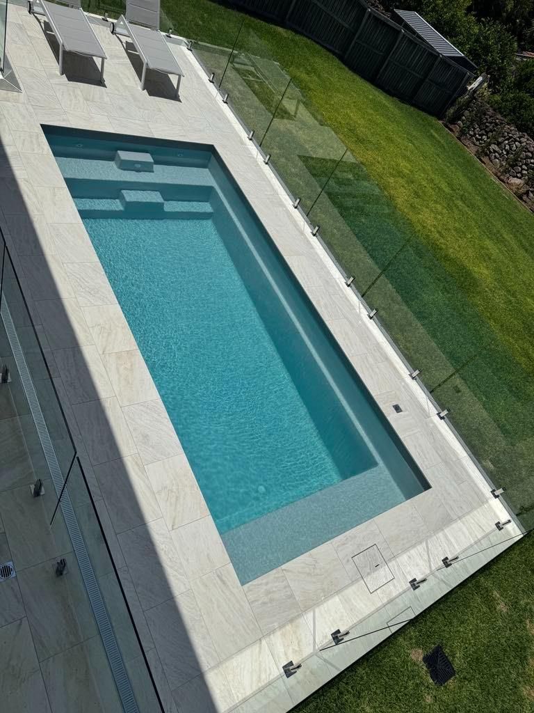 An aerial view of a large swimming pool surrounded by lawn chairs.