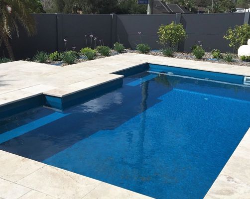 A Large Swimming Pool With Blue Tiles And A Fence In The Background — Evoke Pools In Lennox Head, NSW