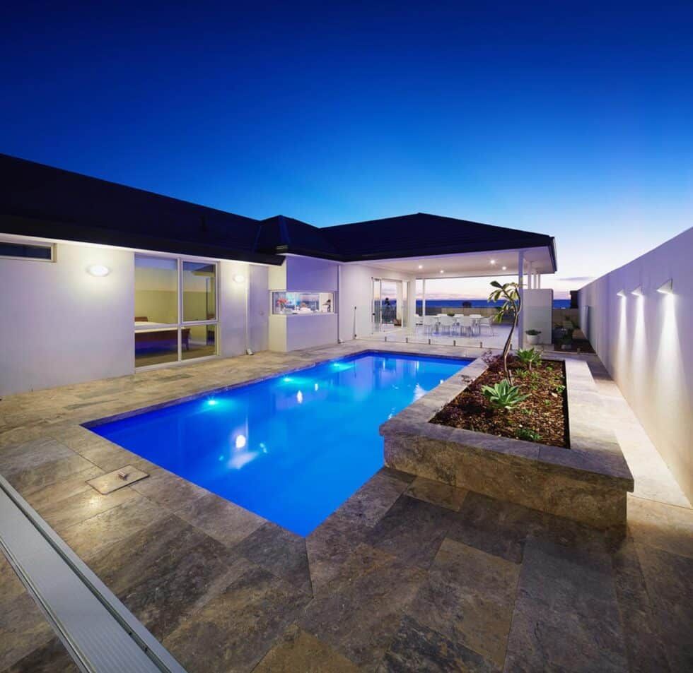 A Large Swimming Pool In The Backyard Of A House — Evoke Pools In Lennox Head, NSW
