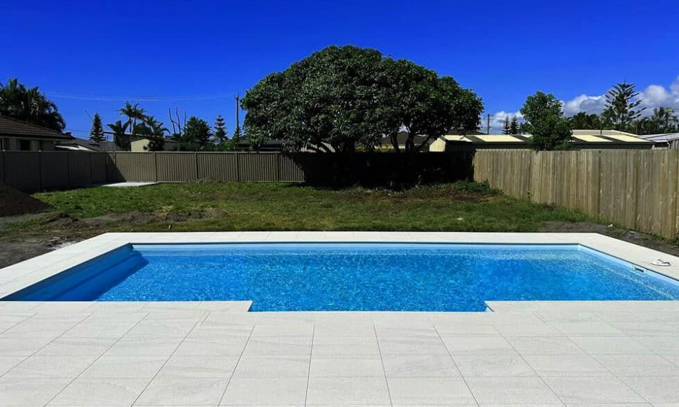 A Large Swimming Pool With A Fence In The Background — Evoke Pools In Lennox Head, NSW