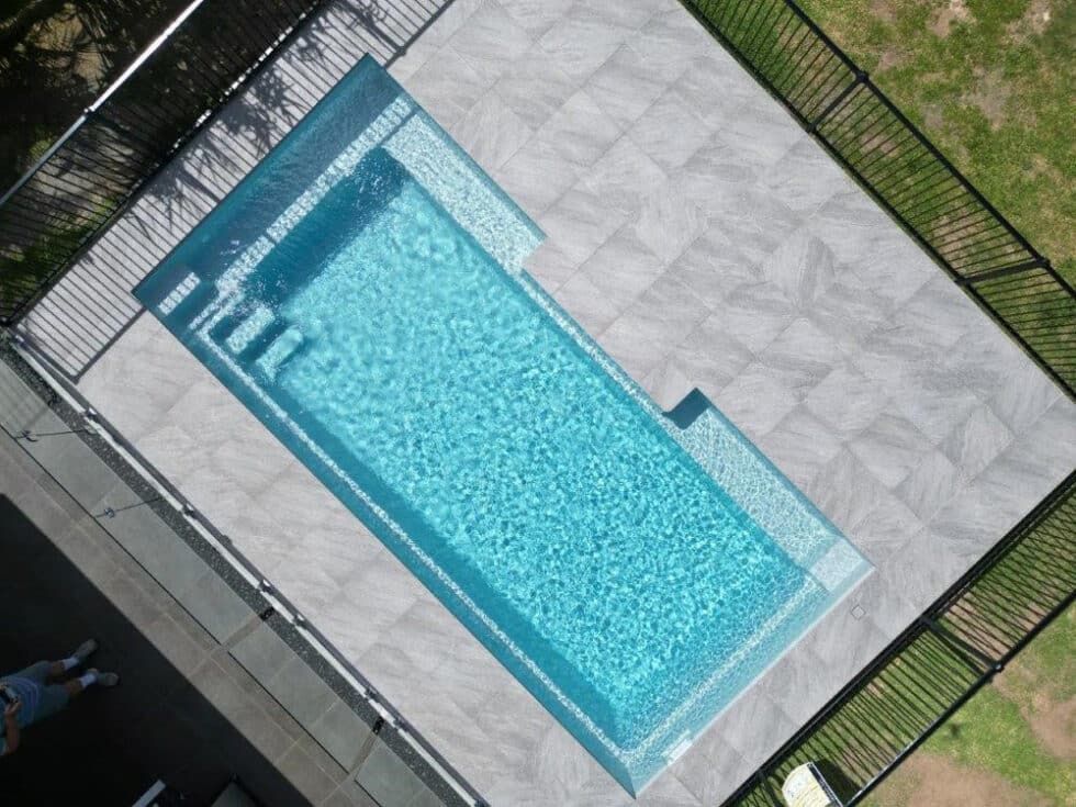 An Aerial View Of A Large Swimming Pool Surrounded By A Fence — Evoke Pools In Lennox Head, NSW