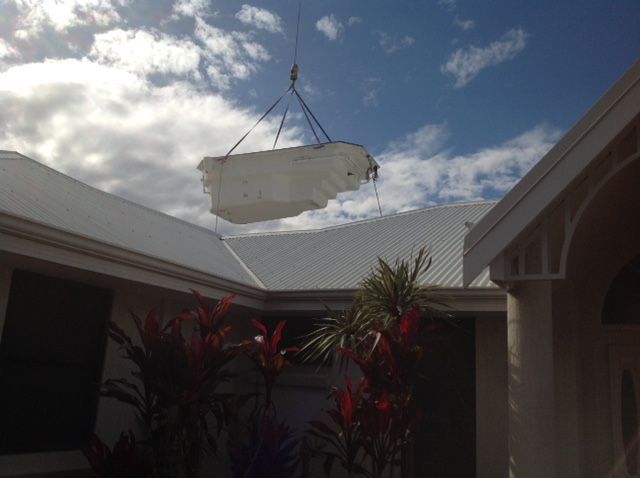 A Swimming Pool Is Being Lifted Into A House By A Crane — Evoke Pools In Lennox Head, NSW