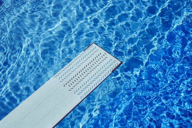 A Diving Board Is In The Middle Of A Swimming Pool — Evoke Pools In Lennox Head, NSW