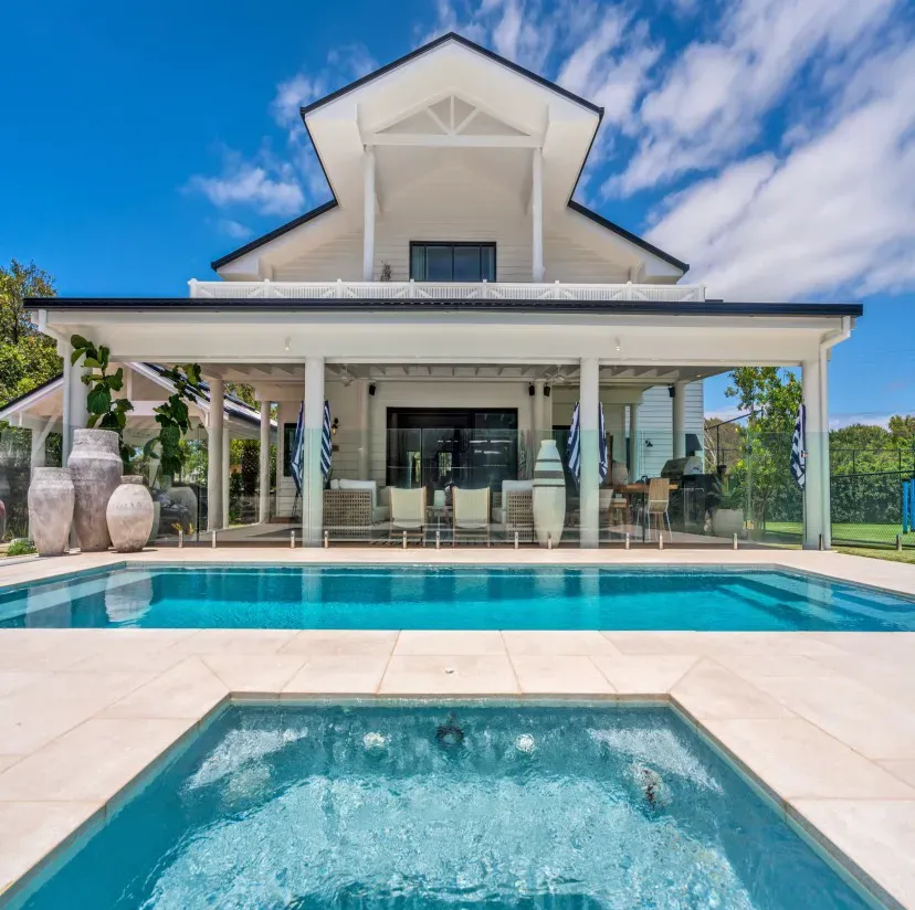 A large house with a large swimming pool in front of it