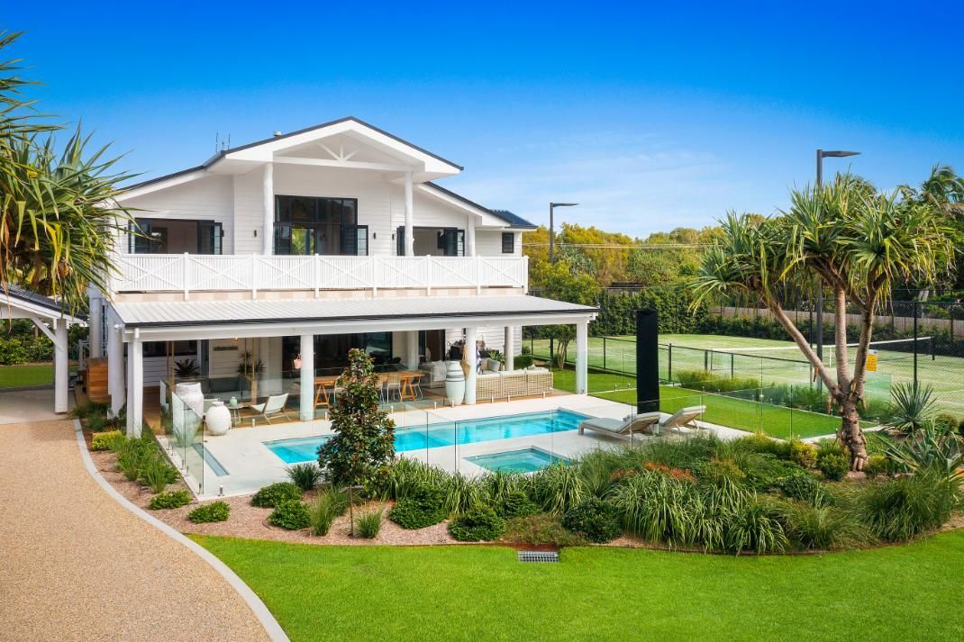 A large white house with a swimming pool in the backyard.