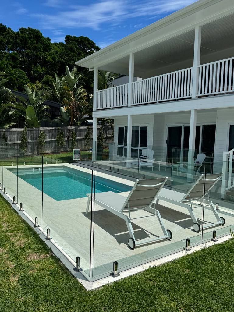 A large white house with a swimming pool in front of it.