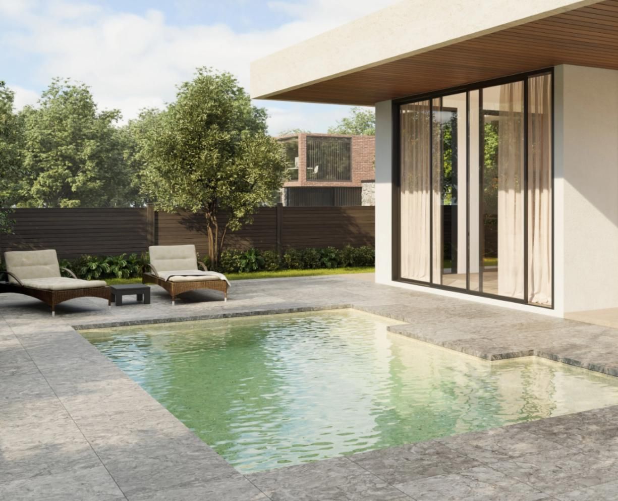 There is a large swimming pool in the backyard of a house.