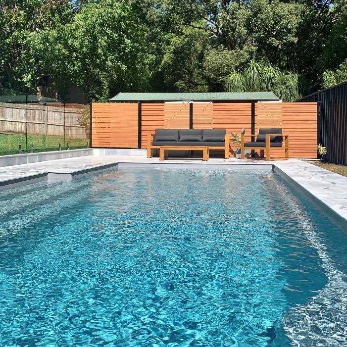 A large swimming pool with a couch and chairs in it.