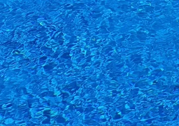 A close up of a blue water surface in a swimming pool.
