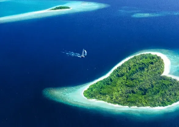 An aerial view of a heart shaped island in the middle of the ocean.