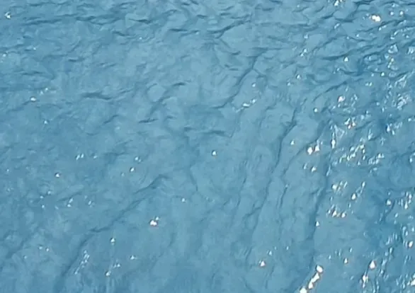 A close up of a blue water surface with waves