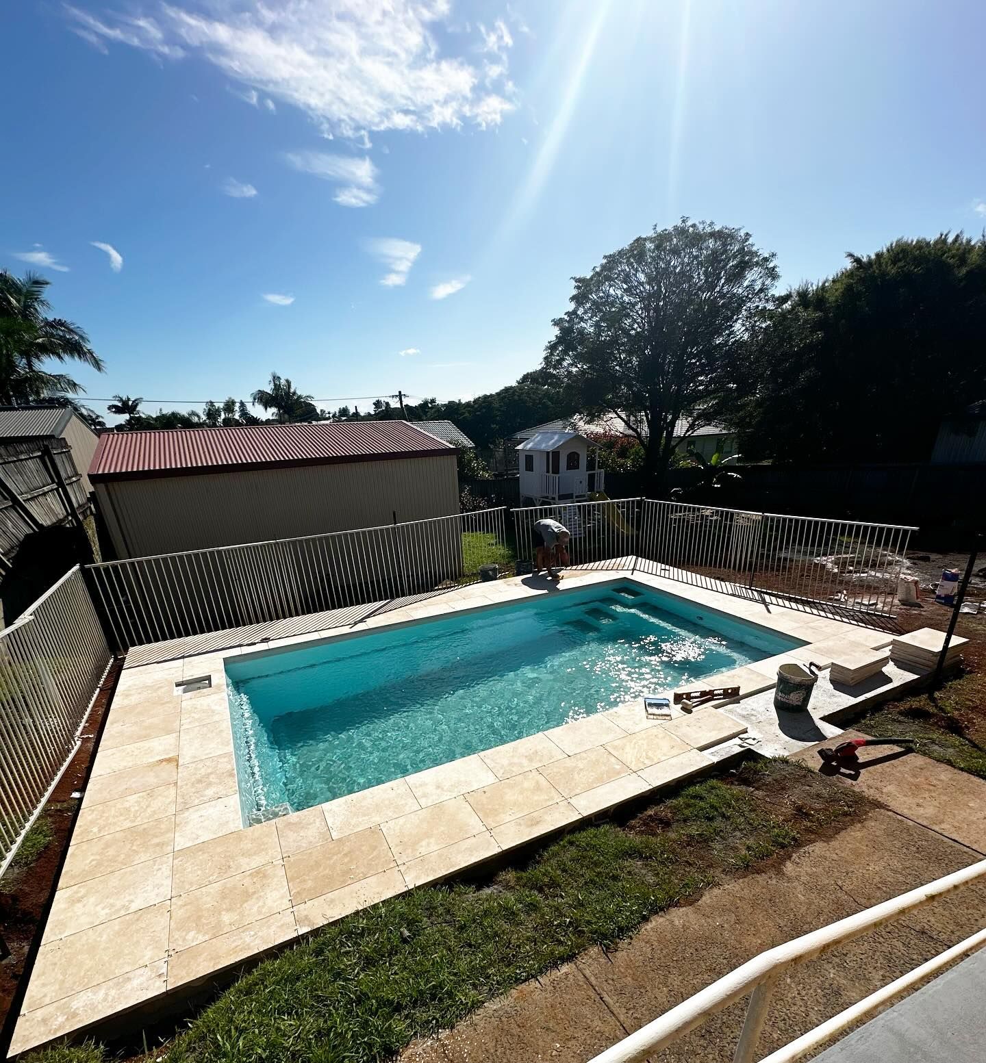 Pool Construction Worker Finishing Fencing In A Backyard