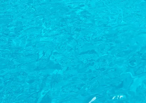 A close up of a blue water surface in a swimming pool.