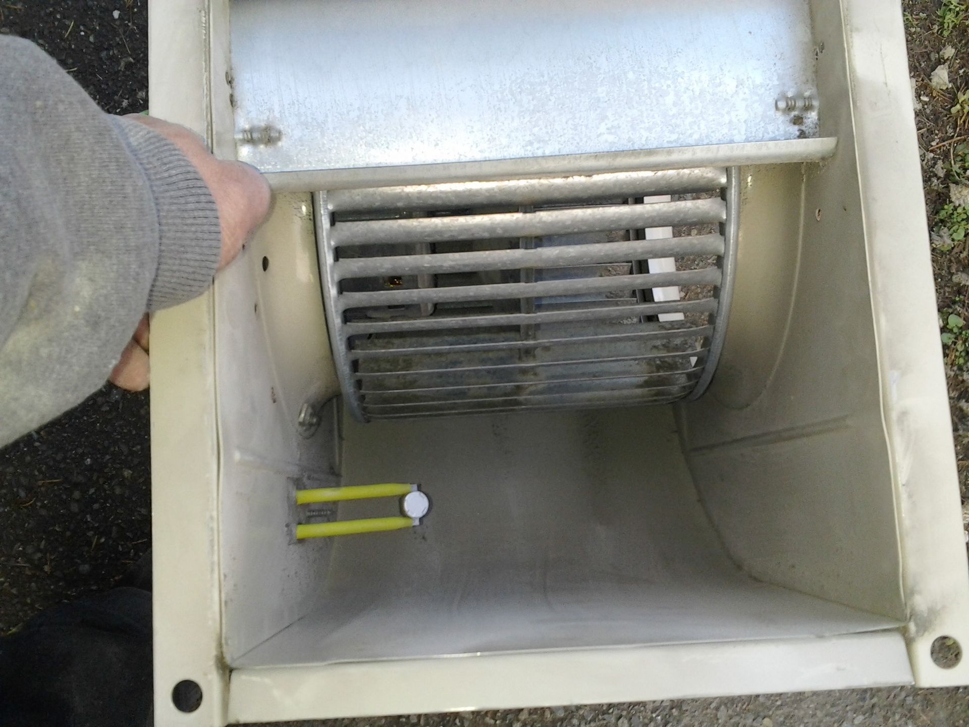 Kings Heating technician hand-cleaning outdoor heat pump unit during repair visit