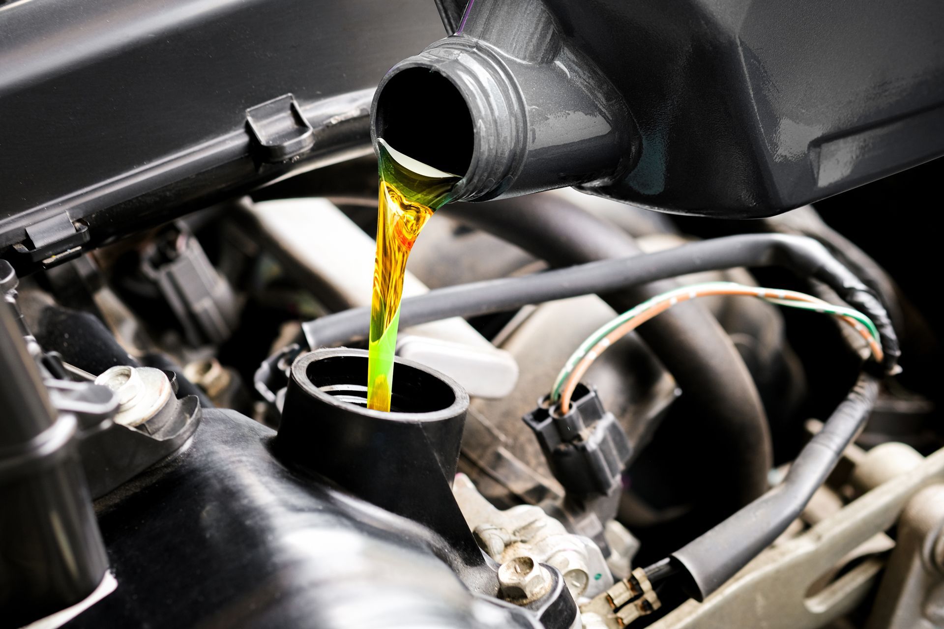 Green coolant being poured into a car engine.