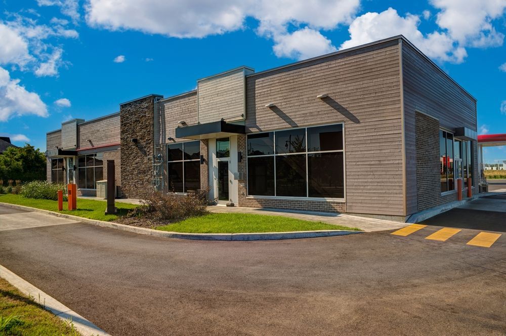 A large building with a lot of windows and a drive thru.