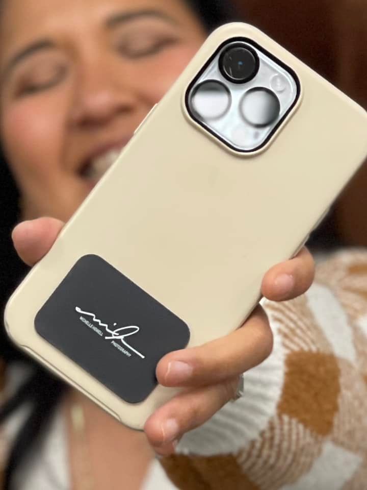Person holding a beige phone with a black card, camera visible.