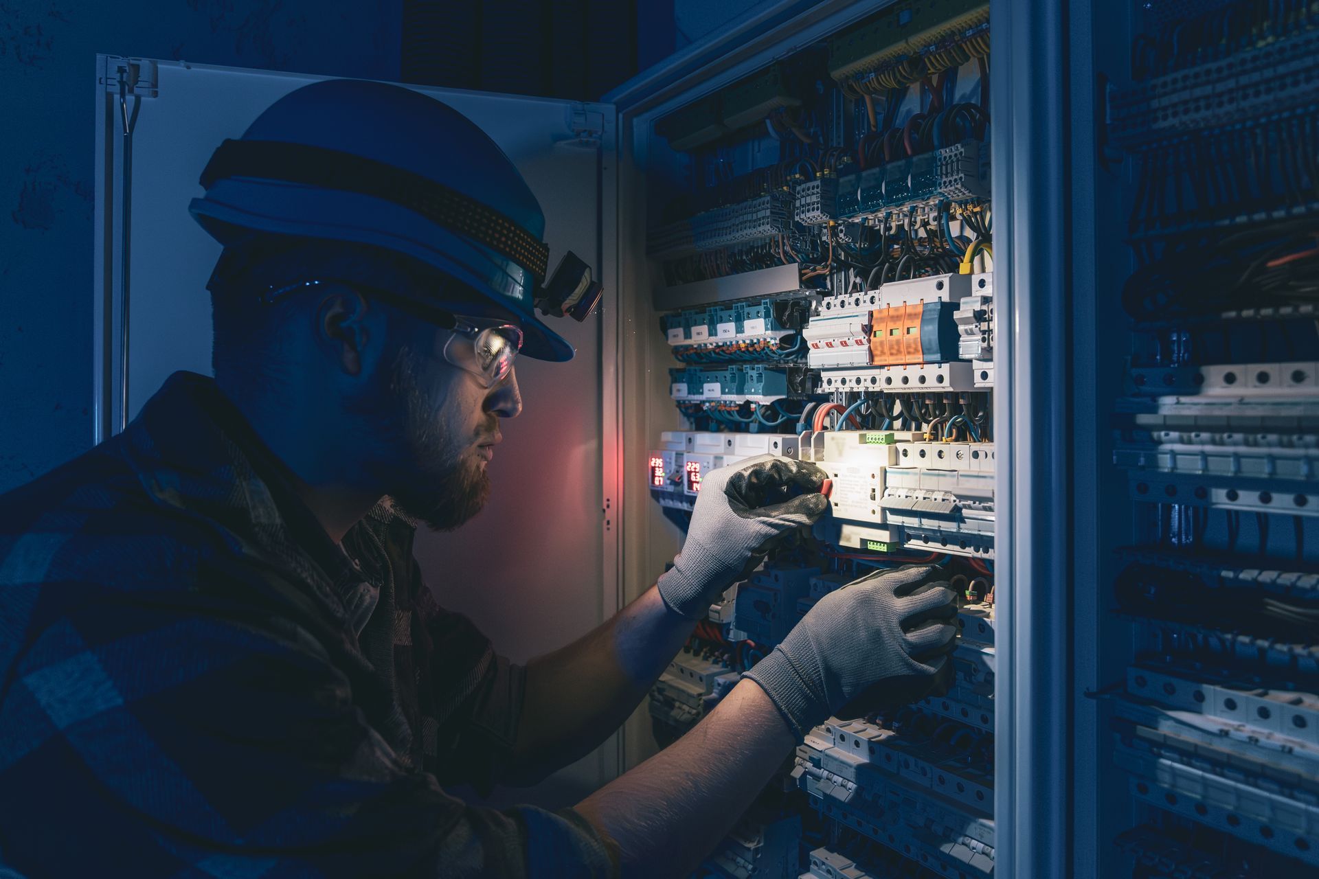 Tangled mass of colorful wires, including blue, yellow, green, and pink, against a dark background.