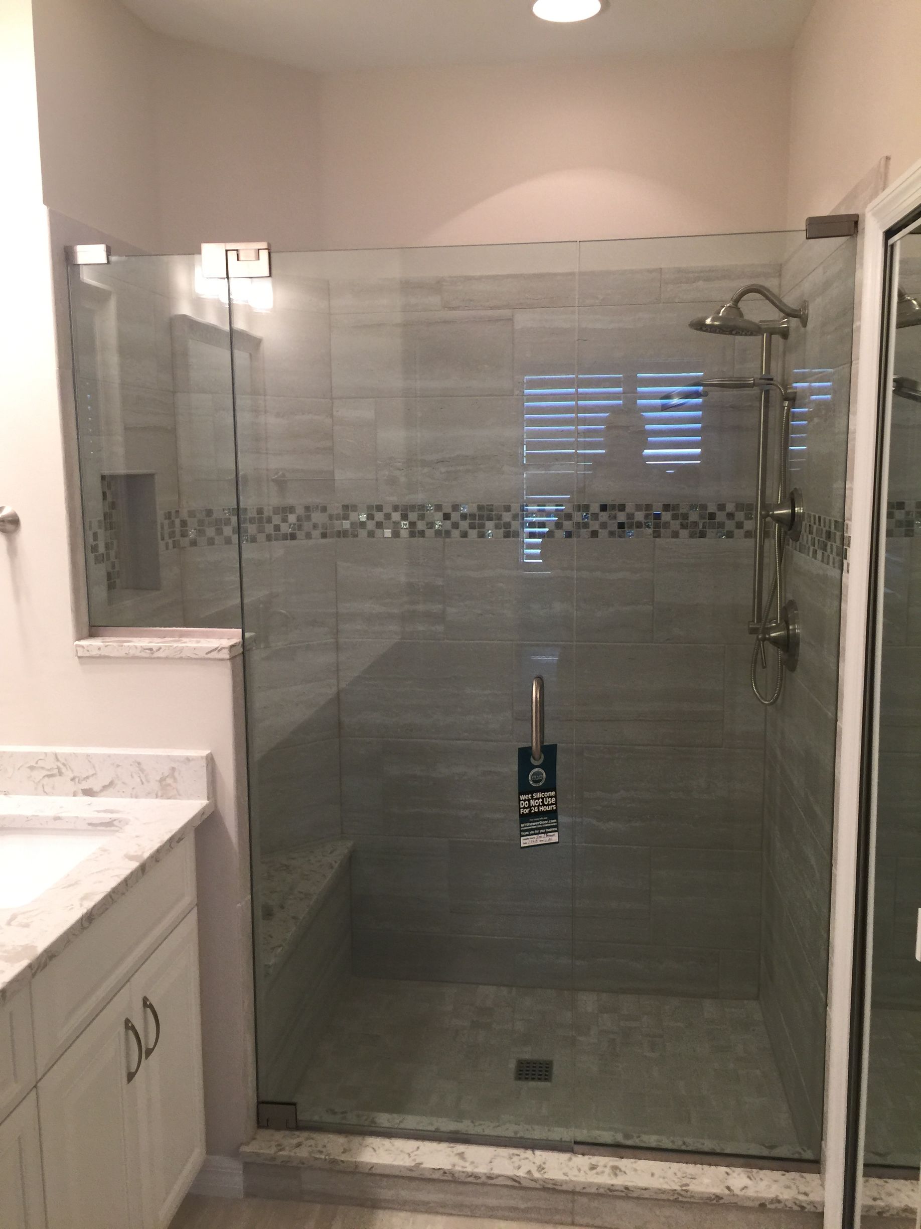 A bathroom with a walk in shower and a sink.