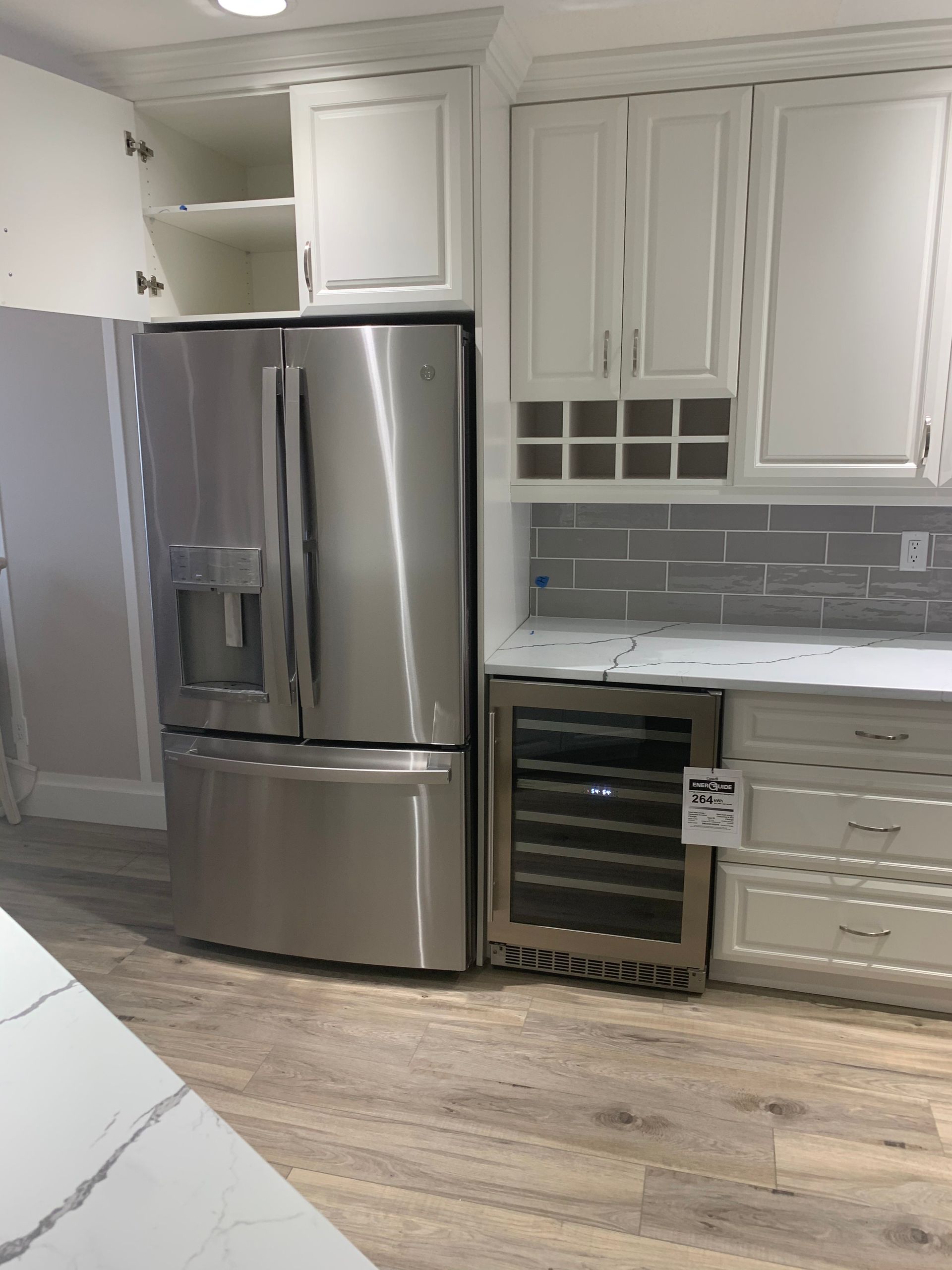 A kitchen with stainless steel appliances and white cabinets.