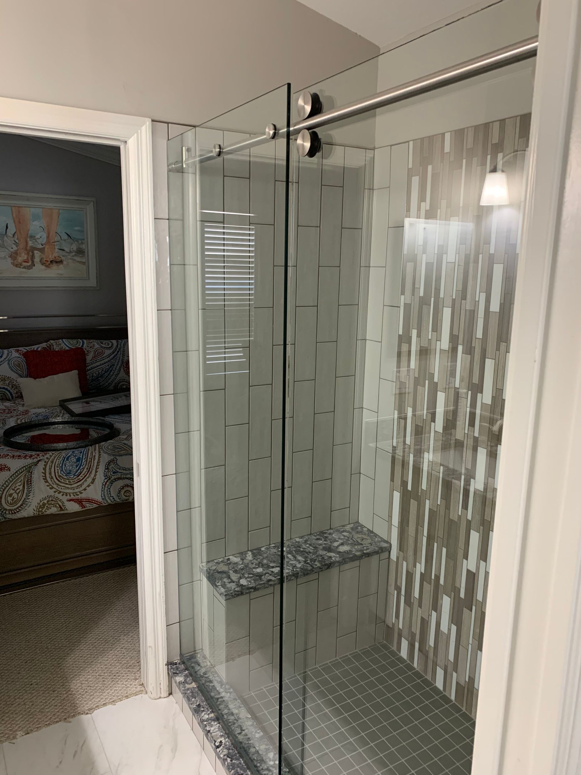 A bathroom with a walk in shower and a sliding glass door.