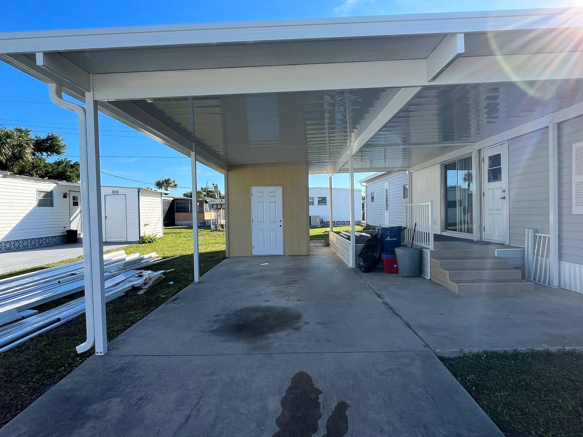 A mobile home with a carport and stairs in front of it.